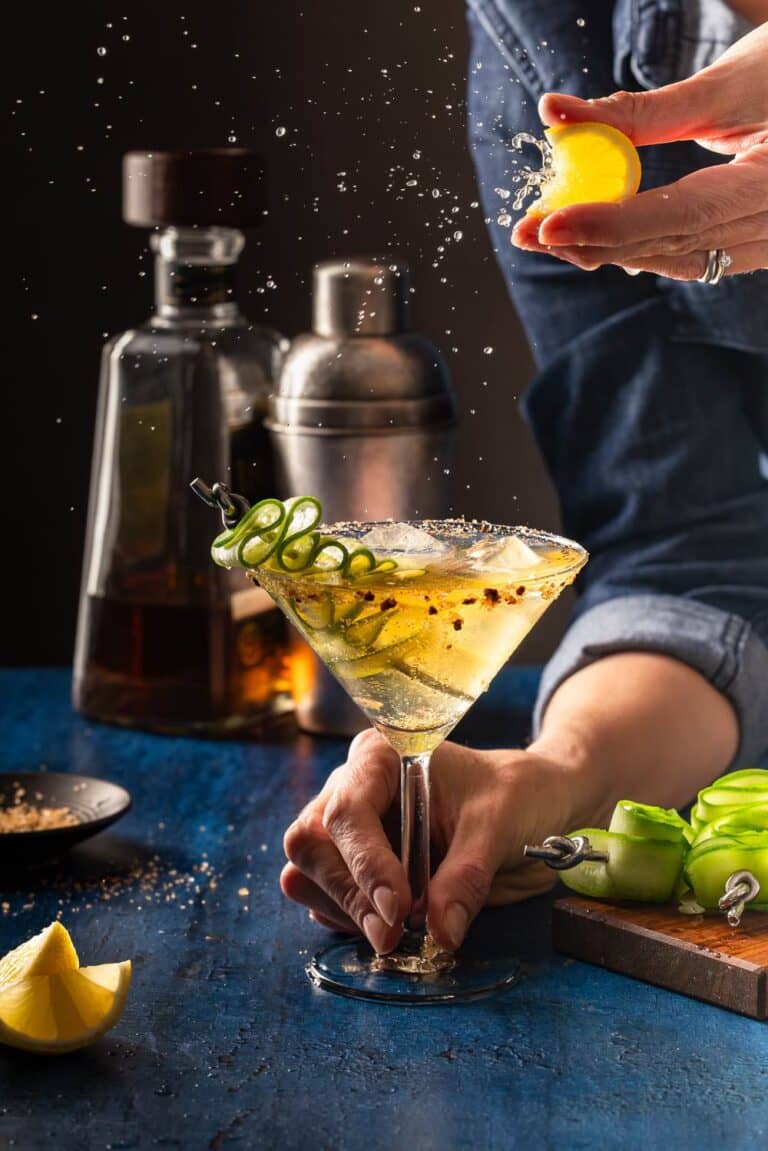 Cocktail mit Gurke und Zitrone im Martini Glas – Lemon Splash im dunklen Bar Setting
